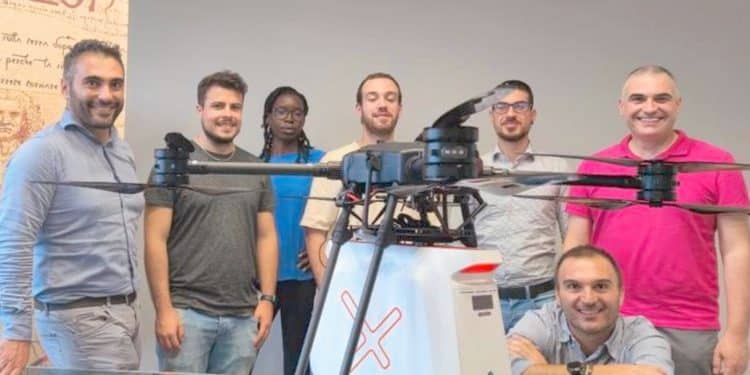 Giuseppe Tortora (a sinistra) insieme al team di Peer2Air e a uno dei droni con la capsula per la consegna a domicilio